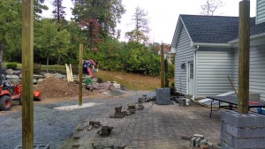 backyard patio under construction with dirt pile in corner