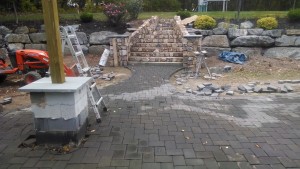 outdoor patio under construction with paver stones in pile