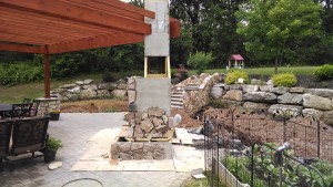Mason Landscaping team installing stones to outdoor fireplace