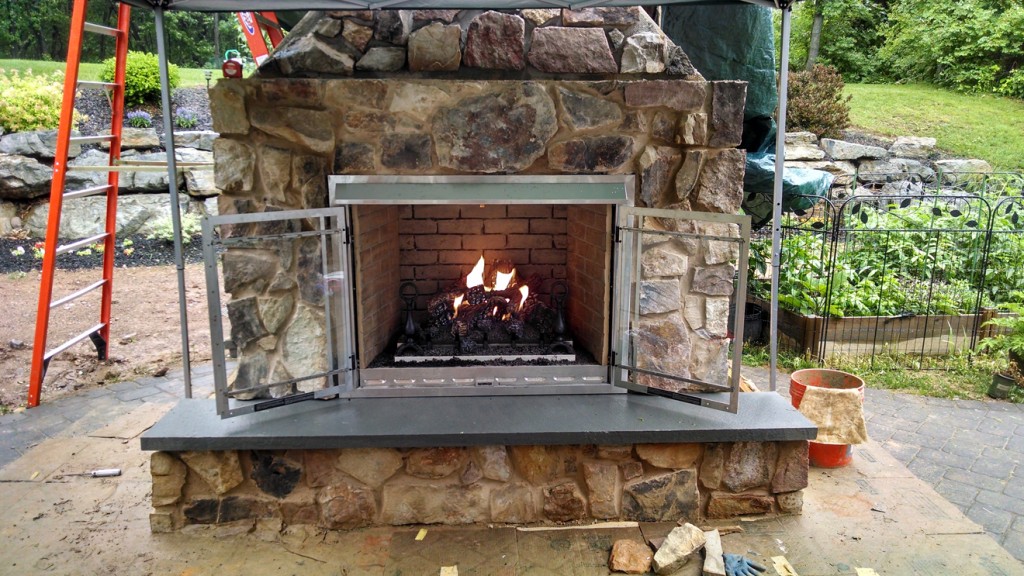 outdoor fireplace with fire burning inside
