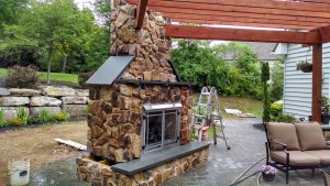 closeup of outdoor stone fireplace in backyard patio